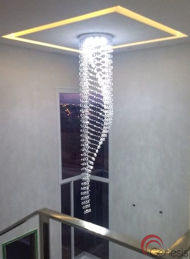 Lustre de cristal design S Rico instalado em sala com pé direito duplo, destacando cristais K9 legítimos da Linha Kria, ideal para ambientes sofisticados.